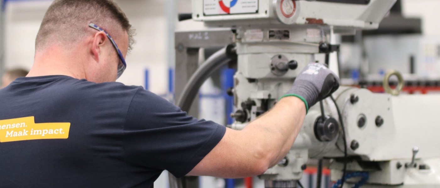 A worker operating machinery on a factory production floor.