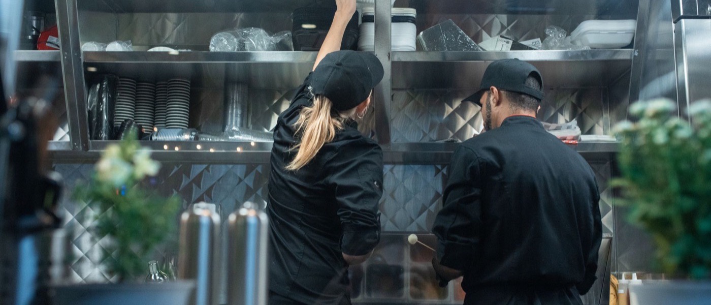 Kitchen staff working the line during service in a commercial restaurant kitchen.