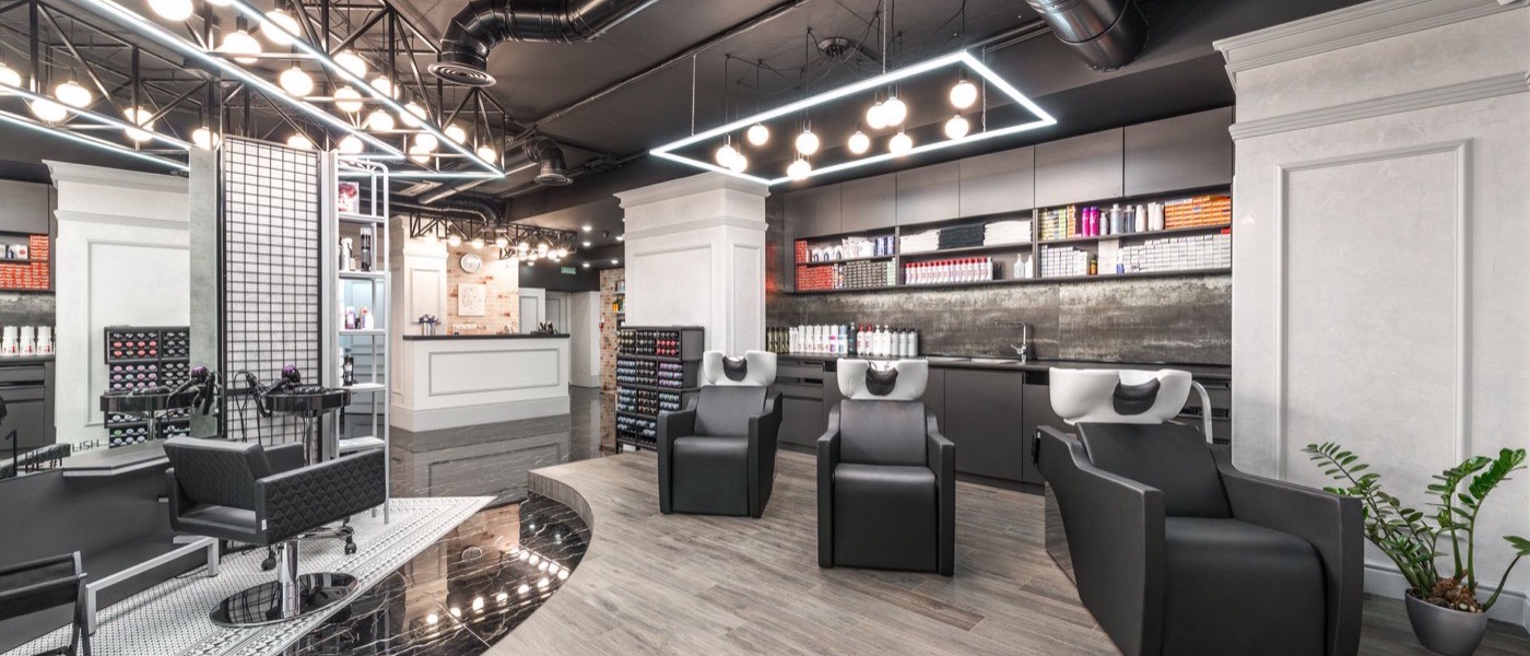 The styling floor of a modern hair salon with chairs and wash stations.